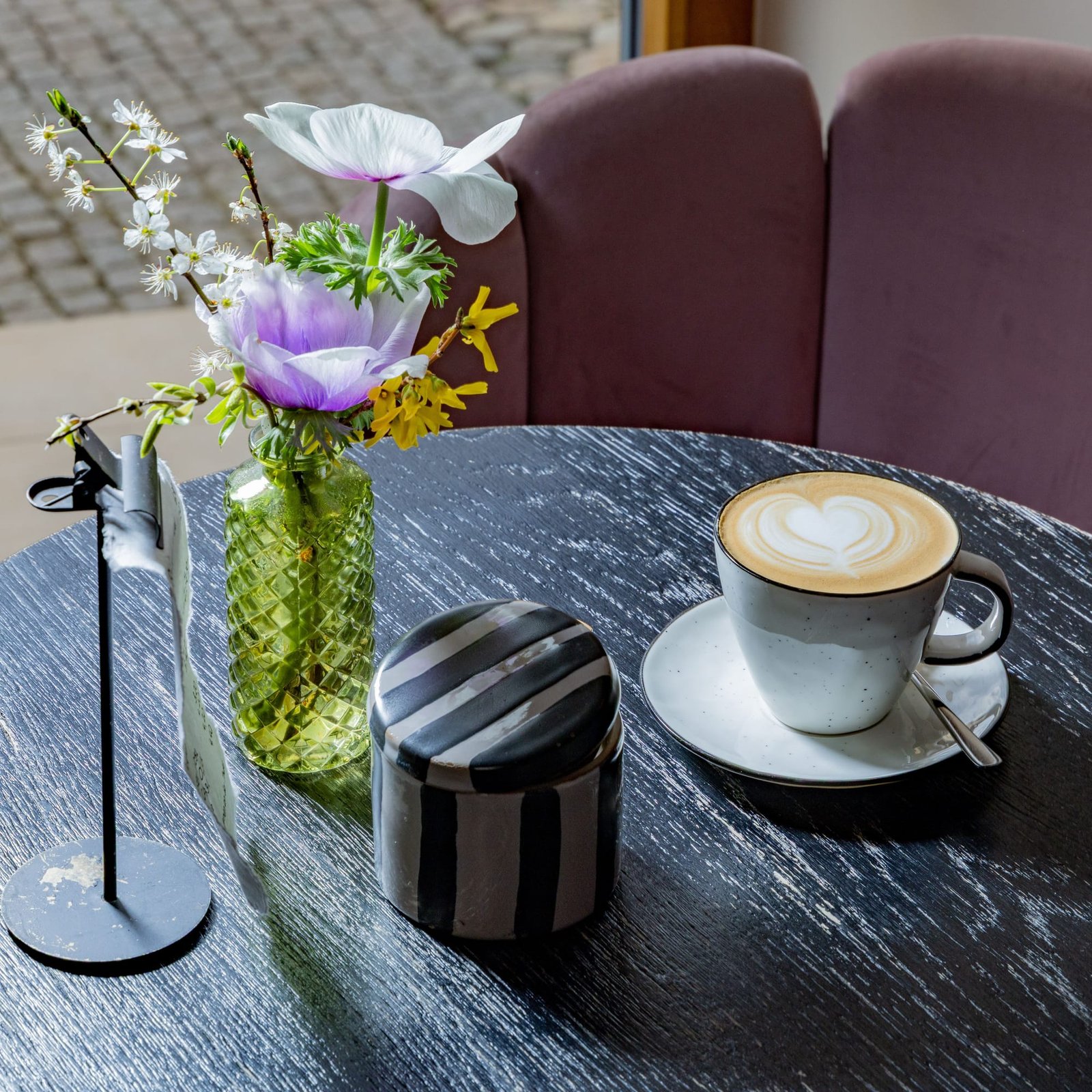 Cappuccino mit Herz-Latte-Art auf dunklem Holztisch im Kamé Café