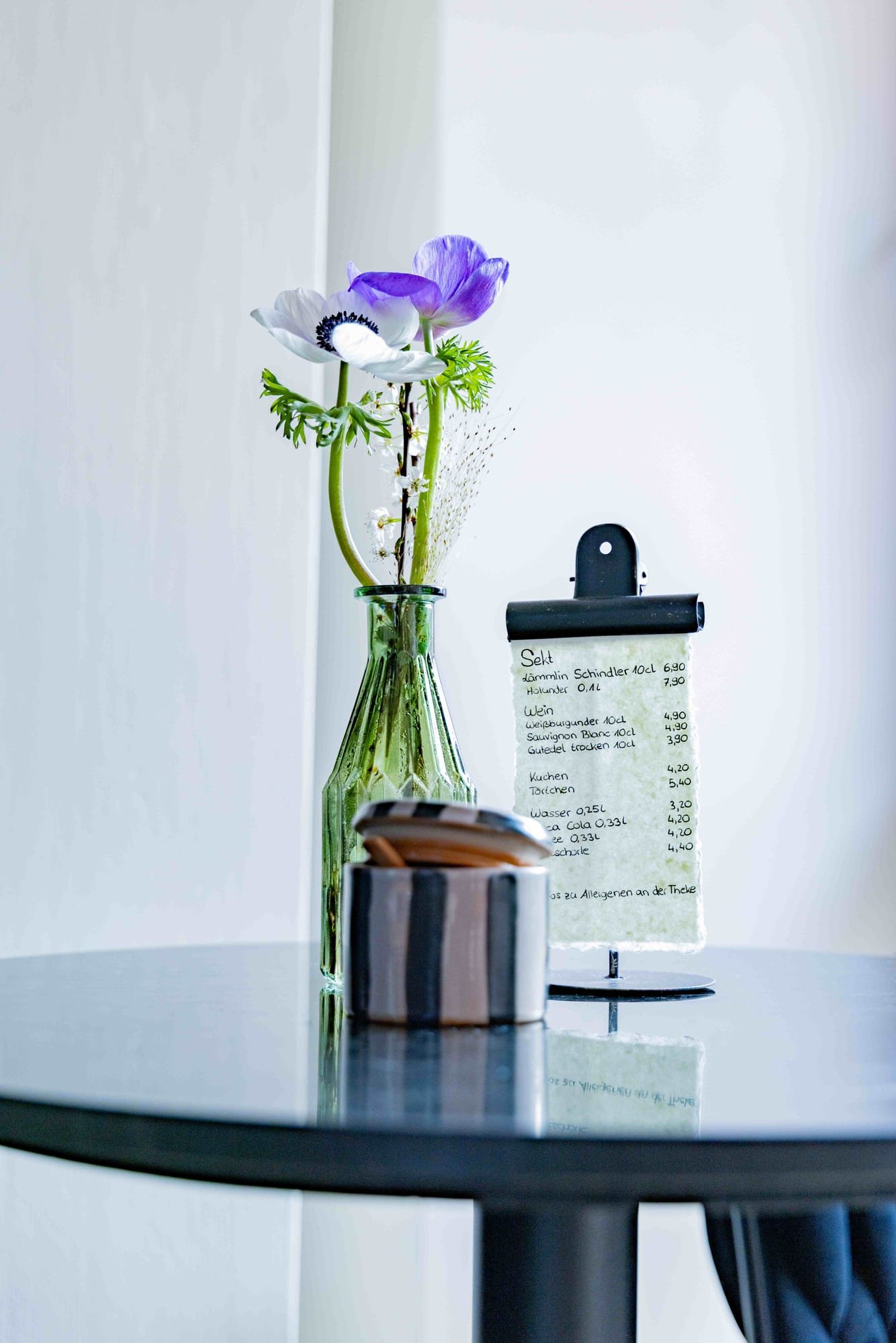 Menükarte mit grüner Vase und gestreifter Keramik