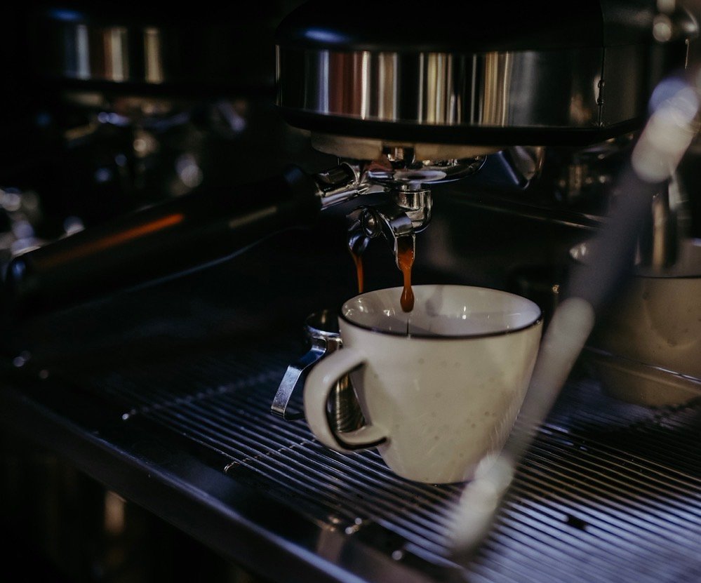 Espressomaschine mit frisch extrahiertem Espresso in einer weißen Tasse