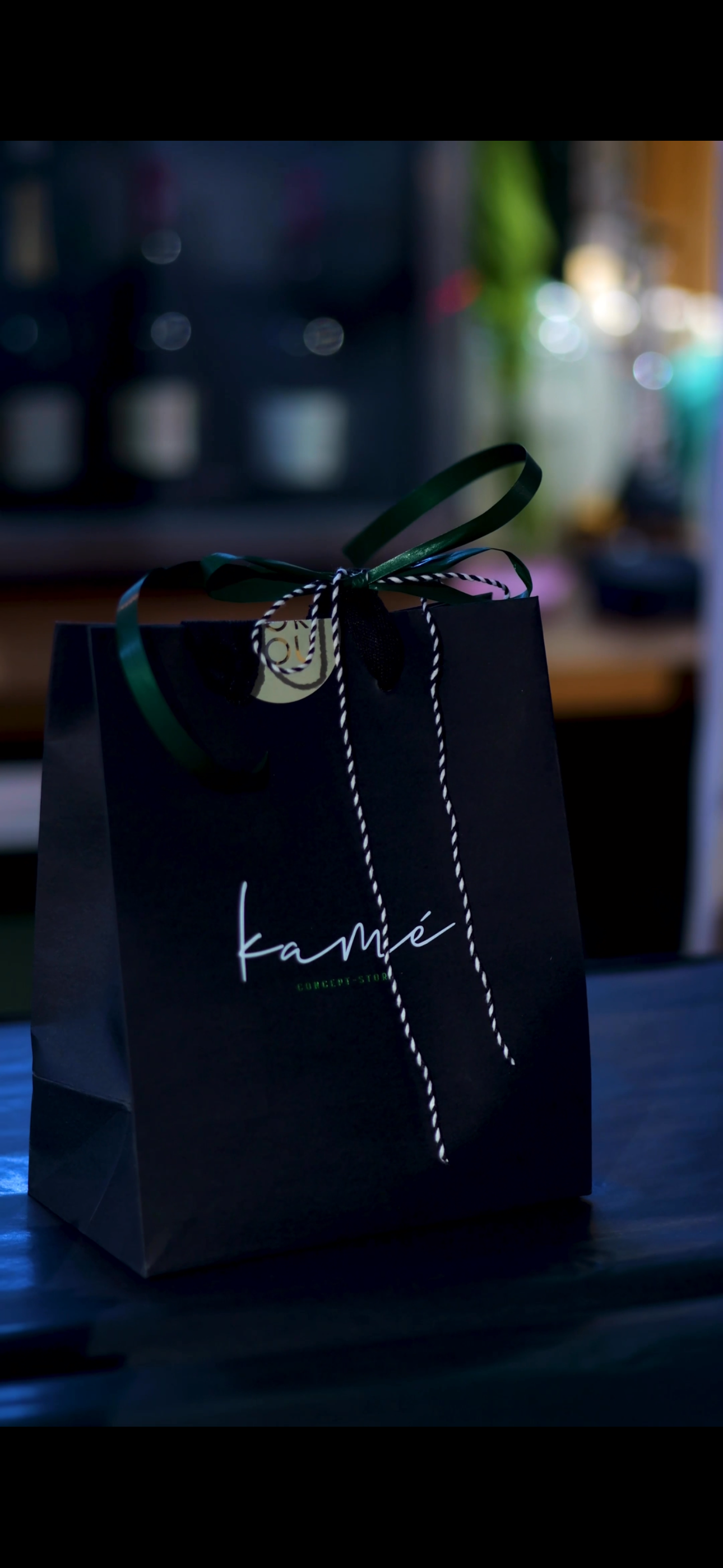 Schwarze Kamé Geschenktüte mit bunten Bändern im Store
